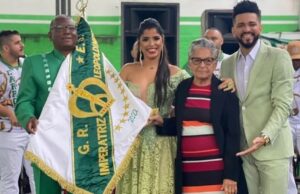 Imagem da filha de Lampião e Maria Bonita ao lado de representantes da escola de samba.