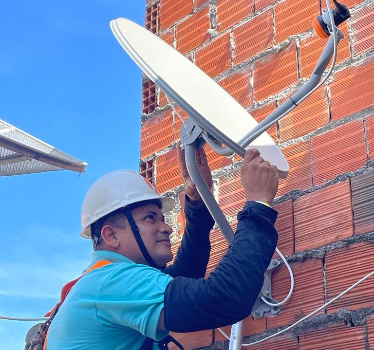 Imagem de técnico fazendo instalação de antena parabólica.