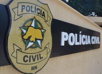 Imagem de brasão da Polícia Civil na fachada do órgão.