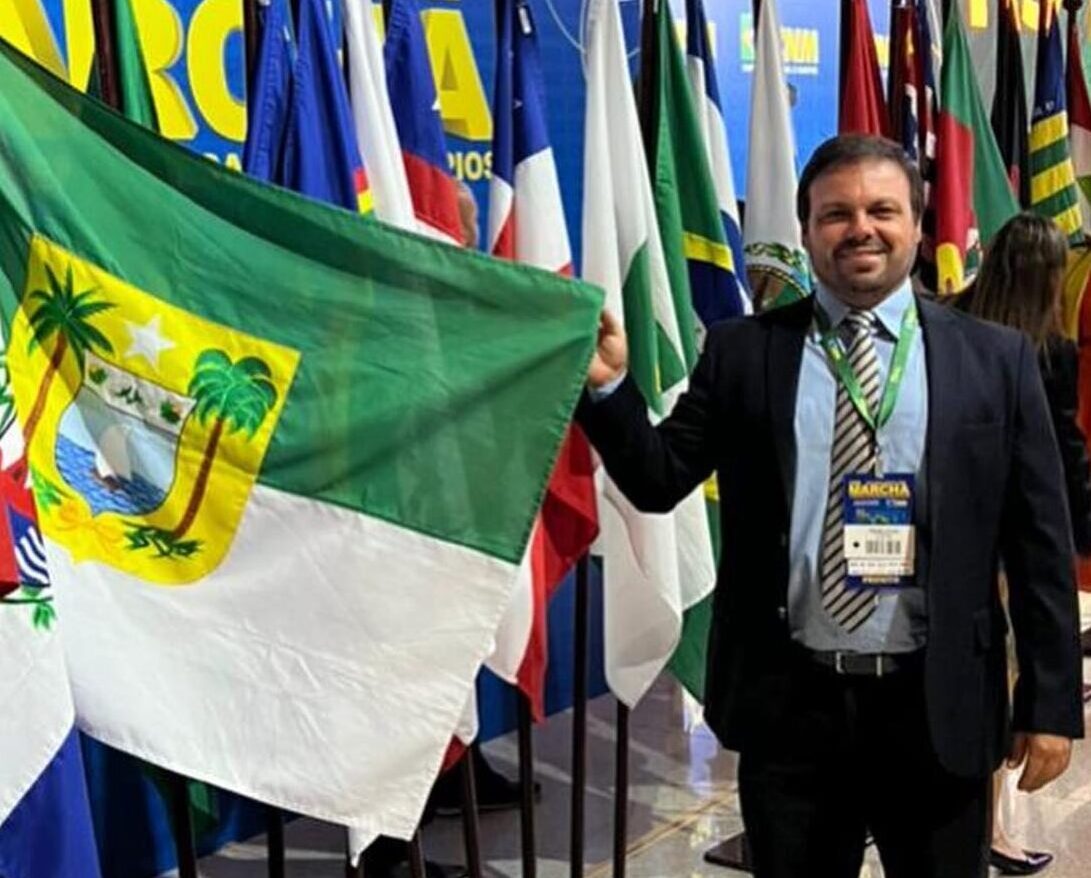 Imagem do prefeito Pedro Filho na Marcha dos Prefeitos em Brasília pegando a bandeira do RN.